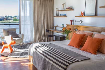 El bloque de muebles que recorre la pared se hizo con enchapado de petiribí, incluyendo la base de la cama con cajones (Victoria D’Ornellas). Almohadones (Mercedes Segura). A modo de pie de cama, alfombra de Elementos Argentinos. Cortinas (Dekoart).