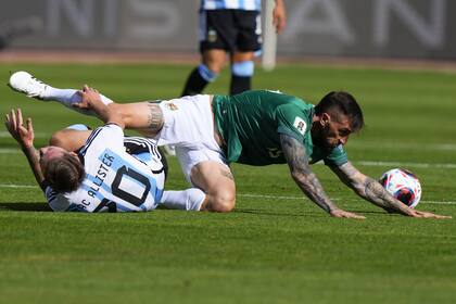 El boliviano Luciano Ursino y el argentino Alexis Mac Allister caen durante un partido de clasificación para la Copa Mundial de la FIFA 2026 en el estadio Hernando Siles de La Paz, Bolivia