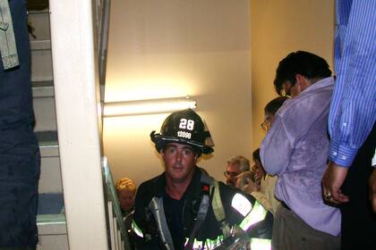 El bombero Mike Kehoe, de Staten Island, ayuda en la evacuación en una escalera de la Torre Uno. Esta fotografía fue tomada por John Labriola que tenía una oficina en el piso 71 del edificio. Ambos pudieron escapar antes de que colapsara la torre
