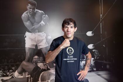 El boxeador mendocino Juan Carrasco, delante de la icónica foto del KO de Muhammad Alí sobre Sonny Liston