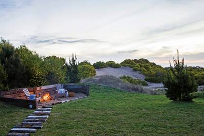 El camino hacia el fogón está marcado con durmientes de quebracho, los mismos que se usaron para crear la estructura que lo repara del viento. Sillones (Constructora VZ).