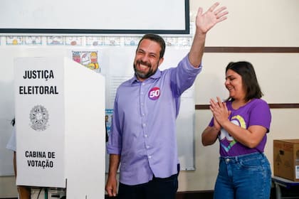 El candidato a la alcaldía de Sao Paulo Guilherme Boulos, por el partido Socialismo e Liberdade (PSOL), saluda junto a su esposa Natalia Szermeta (d) mientras deposita su voto durante la primera vuelta de las elecciones municipales, en Sao Paulo, Brasil, el 6 de octubre de 2024.