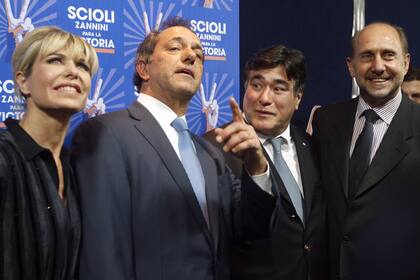 El candidato a presidente por el Frente para la Victoria Daniel Scioli junto a su esposa, Karina Rabolini, y su fórmula, Carlos Zannini