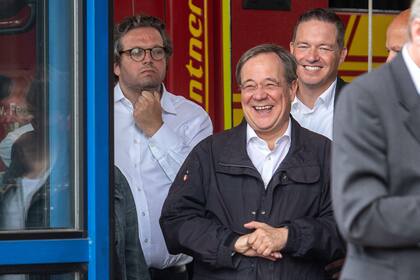 El candidato de la CDU a la Cancillería Armin Laschet (centro) rie mientras el presidente alemán (invisible) pronuncia un discurso después de que visitaron el centro de control de incendios y rescate de Rhein-Erft y en Erftstadt, en el oeste de Alemania, el 17 de julio de 2021
