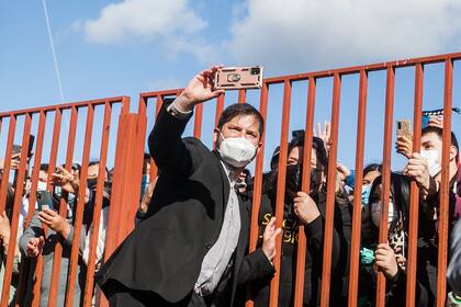 El candidato presidencial izquierdista Gabriel Boric se toma selfies con la gente fuera de un colegio electoral durante la segunda vuelta de las elecciones presidenciales en Punta Arenas, Chile, el domingo 19 de diciembre de 2021.