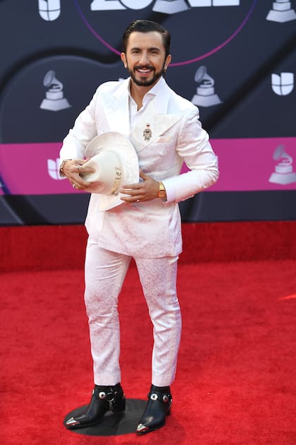 El cantante y compositor colombiano Nabález, con un traje blanco, sombrero y botas texanas