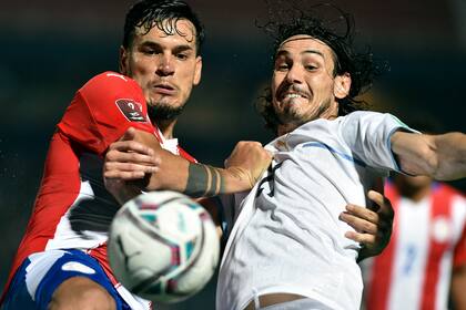 El capitán paraguayo Gustavo Gómez, que fue expulsado por el árbitro argentino Darío Herrera, forcejea con Edinson Cavani, el delantero uruguayo que saltó desde el banco de los suplentes en el segundo tiempo