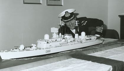 El capitán Paul Hoddinott comandante del destructor (D-88) HMS Glasgow que participó en el conflicto del Atlántico Sur, inspecciona una réplica a escala de su navío de guerra en 1983. (Cortesía The Bulletin).