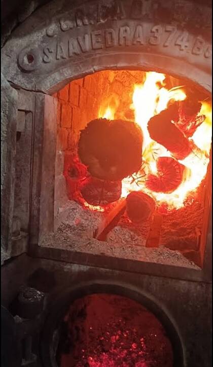El centenario horno a leña de la panadería hornea 250 kilos de pan por día.
