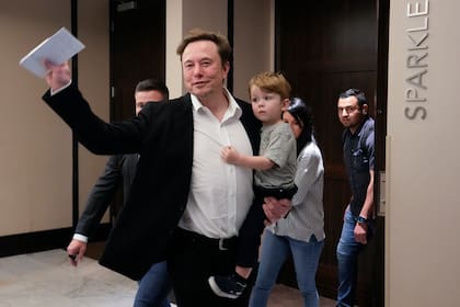 El CEO de Twitter, Elon Musk, carga a su hijo cuando se va después de hablar en una conferencia de marketing en Florida
