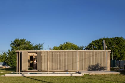 El cerramiento grisáceo de WPC unifica la fachada y controla la transparencia, creando una presencia monolítica hacia el jardín.