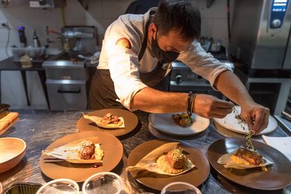 El chef jujeño Walter Leal les da los toques finales a los platos de Finca Cocina Urbana, restaurante de alta gama en el centro histórico de San Salvador.

