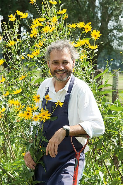 El chef Sébastien Foullade es francés pero está radicado en la Argentina, donde dirige la empresa de catering. En la foto, sostiene las flores de topinambur, que aparecen febrero y son comestibles.