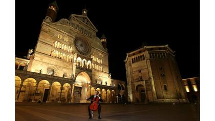El chelista Fausto Solci toca su instrumento en el centro de la ciudad de Cremona junto al Duomo