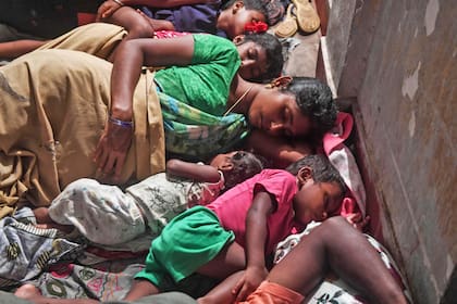 Una mujer que fue evacuada junto a sus hijos, permanece en un refugio hasta que se termine la tormenta