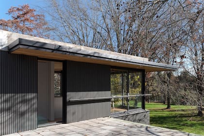 El cielo raso de madera también se extiende hacia el exterior en esta planta, a modo de pérgola perimetral, para cubrir algunos metros de la terraza.