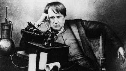 El científico Thomas Edison escucha su fonógrafo a través de un primitivo auricular