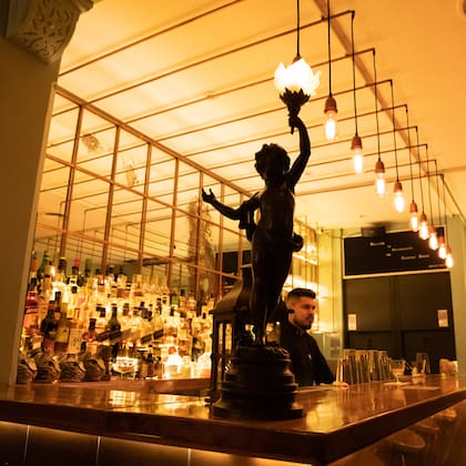 El cobre resalta en la barra, con banquetas para los que eligen hablar con el bartender