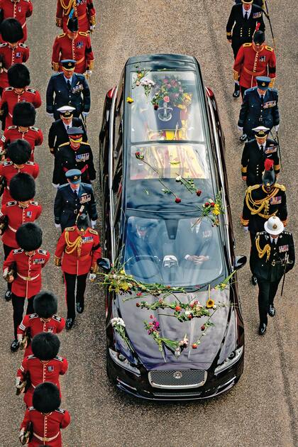 El coche fúnebre, un Jaguar Land-Rover especial, en cuyo diseño participó la soberana en vida, llegó bañado en flores.