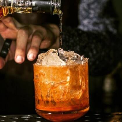 El cóctel lleva Bourbon, bitter Angostura, azúcar, una rodaja de naranja y unas gotas de soda.