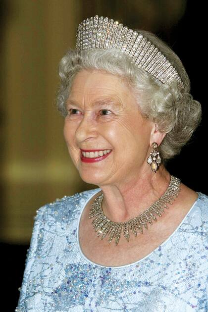 El cofre real de Isabel, entre sus joyas personales y las de la Corona, tiene un valor incalculable. Una de las piezas más llamativas es la tiara Rusa Fringe de diamantes, que luce en esta foto. Lleva también un collar y aros de diamantes.