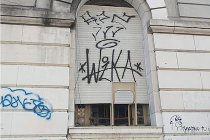El colegio Normal 1 de La Plata. La fachada vandalizada y una silla como soporte para mantener una persiana abierta