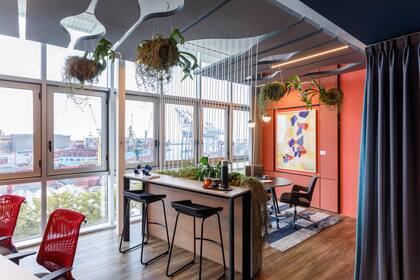 El color azul marca los espacios de concentración, mientras que el terracota, la madera y las plantas colgantes generan zonas más cálidas y confortables