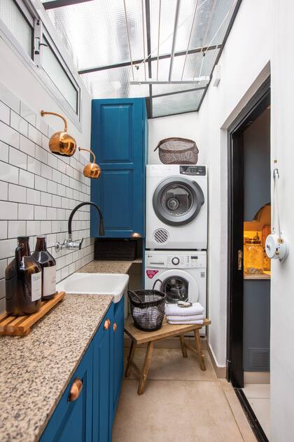 El color cobre es el hilo conductor entre el lavadero y la cocina que conectan visualmente gracias a un gran ventanal y una puerta a la que le calaron vidrio repartido