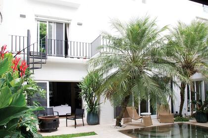 El color de las macetas del sector del fogonero se funde y conecta con el agua de la pileta y con la tonalidad del mural.