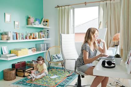 El color y los accesorios sirven para segmentar sectores: aquí, la pared aqua es el marco perfecto para la biblioteca y la alfombra genera un sector de lectura apartado del área del escritorio