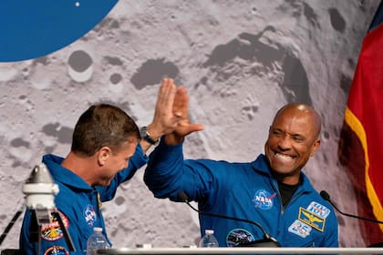 El comandante Reid Wiseman y el piloto Victor Glover chocan sus manos durante la conferencia de prensa en Houston