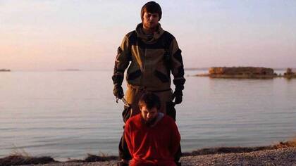 El combatiente de EI junto a su víctima rusa