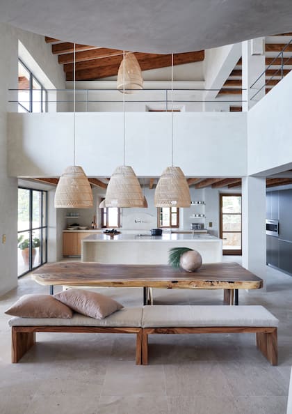 El comedor común, con mesa y
bancos de madera iluminados por el mismo tipo de lámpara del living