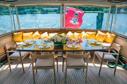 El comedor de popa cuenta con espacio suficiente para una comida familiar. En días de calor, se puede levantar los paneles para disfrutar del viento del mar