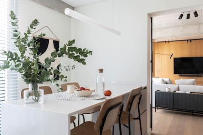 El comedor, el living e incluso la cocina generan una sensación de continuidad a partir de una cuidadosa elección de elementos y texturas.