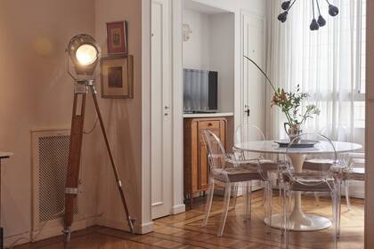 El comedor está conectado con el living, pero la parte más iluminada. La eleccipon de las cortinas de gasa y las sillas transparentes aumenta la levedad general