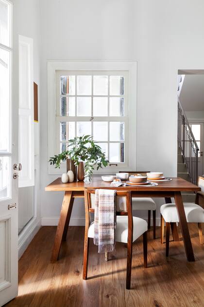 El comedor (Estee Deco) se viste de invierno con un arreglo de ramas y una manta de lana escocesa.