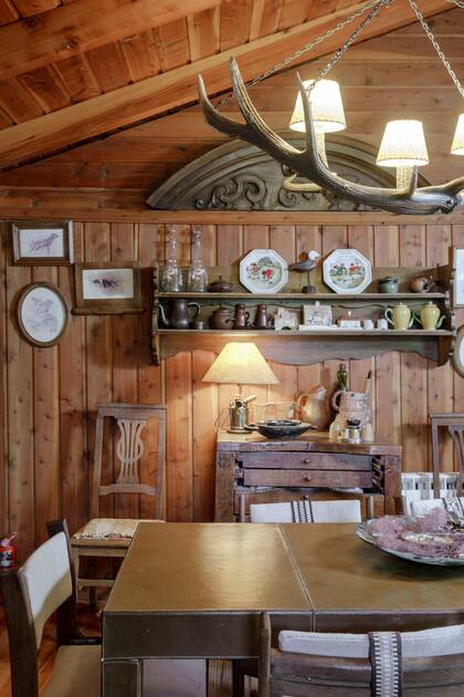 El comedor, iluminado por una clásica lámpara de astas de ciervo.