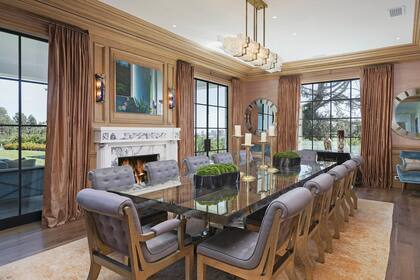 El comedor, para doce comensales, tiene grandes ventanales con vista al extenso jardín.