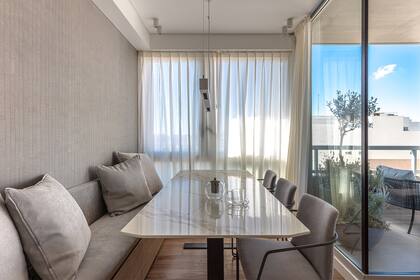 El comedor recibe mucha luz de mañana desde el balcón de 8m2, por eso ese rincón vidriado está protegido con cortinas, colgadas de distinto modo.