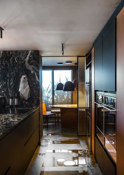 El comedor se puede cerrar con una puerta corrediza de vidrio acanalado de Vasa ejecutada por Fusión Aberturas.