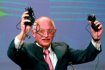 El comisario europeo de Empresa e Industria, Günter Verheugen, muestra los cargadores universales que los fabricantes del sector aceptaron desarrollar