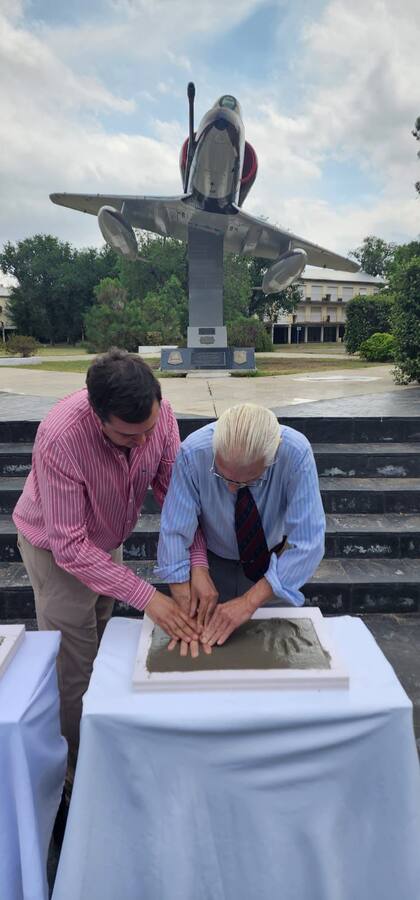 El comodoro Dubourg apoya sus manos sobre el cemento en Villa Reynolds secundado por el Dr. Mario Paradelo. (Gentileza Luis Cervera).