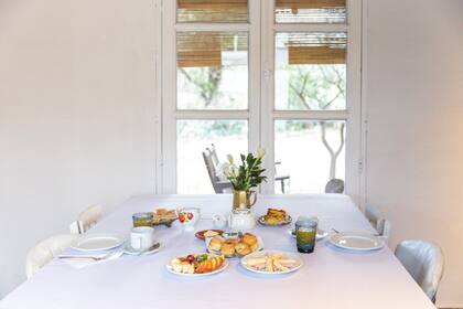 El completo y artesanal desayuno servido en la mesa de la posada, con vista al campo.