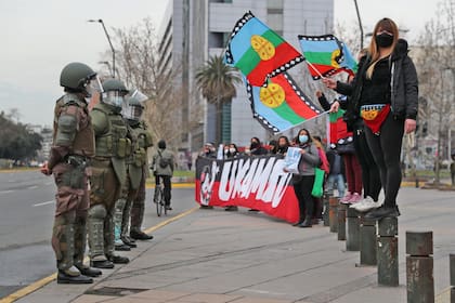 Manifestantes ondean banderas de los mapuche frente a los agentes de la policía antidisturbios durante una protesta contra el gobierno de Chile, el 28 de agosto pasado