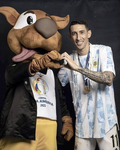 El corazón de Di María, aquí, formado con "Pibe", la mascota de la Copa América Brasil 2021; un torneo que entró para siempre en la vida del rosarino