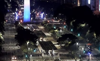 El cordón de policías avanza por los carriles de la 9 de julio para despejarlos