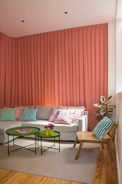 El cortinado (Hilo) mejora la acústica y le da un clima íntimo al living. El sillón en L (Goral Deco) y la alfombra (EL Espartano) en tonos beige suman calidez.