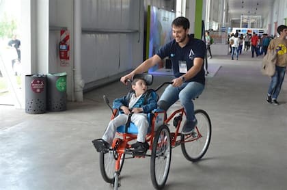 El creador de ErniBike, Diego Blas, da la primera vuelta en el rodado junto a Ernesto, el niño con discapacidad cerebral que la inspiró