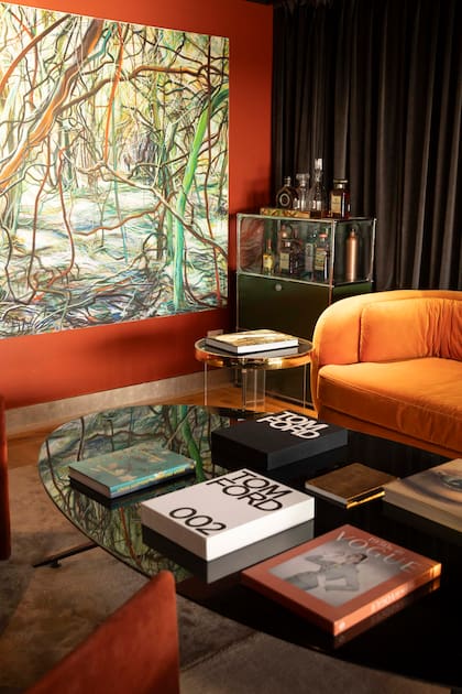 El cuadro del bosque aporta profundidad y movimiento al estar, dialogando con la paleta cálida del espacio.